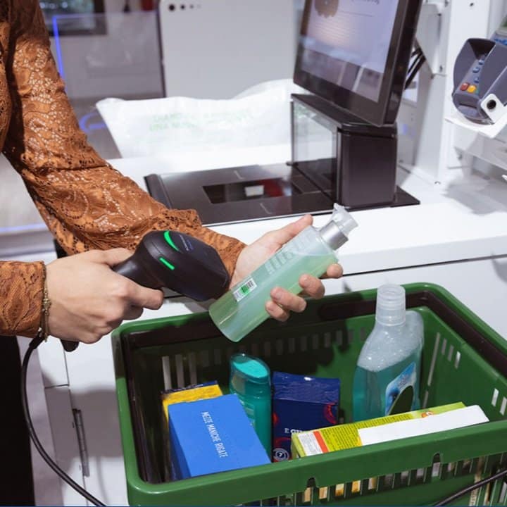A woman using a self check-out device.